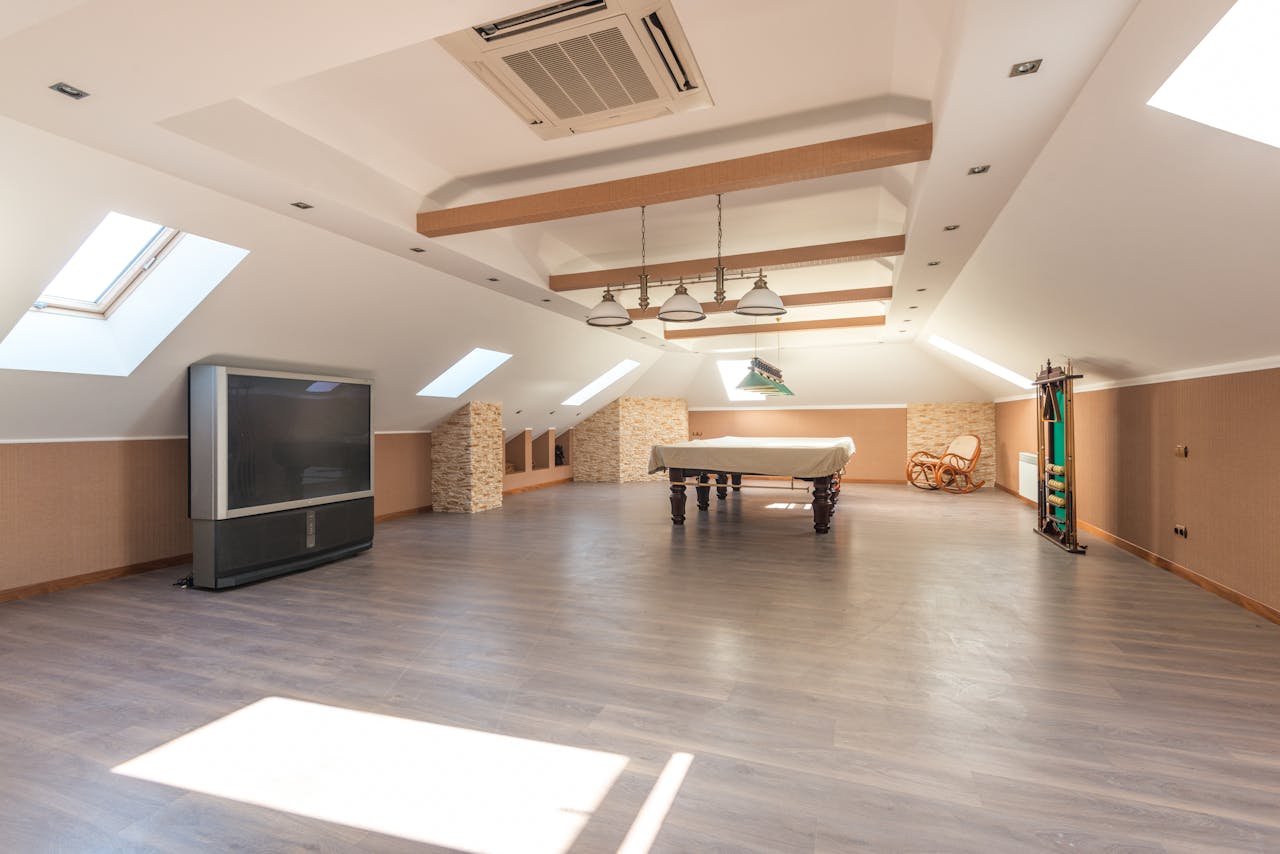 services-02 Bright attic space featuring a sleek pool table and skylights, perfect for leisure.